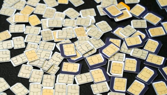 Multiple SIM cards scattered on a black surface, showcasing the complexity of cellular technology.