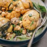 Close-up of a traditional Balut dish garnished with herbs and spices, showcasing its exquisite presentation.