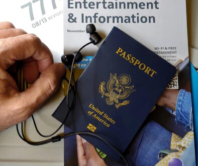 Close-up of US passport with inflight magazine and headphones on an airplane seat, ready for travel.